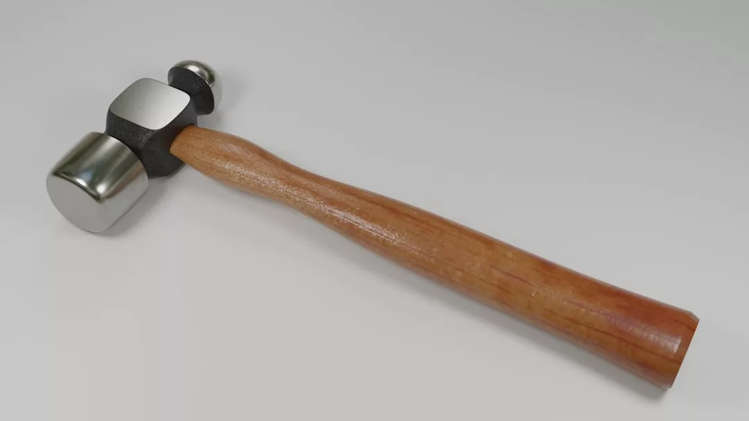 Un martillo de metal con una doble cabeza pulida y un mango de madera, elaborado con lujo, se coloca sobre una superficie blanca lisa, reflejando la elegancia atemporal que se encuentra en Mallorca.